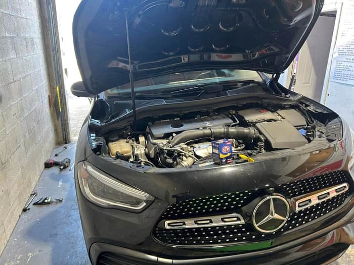 Black Mercedes-Benz with hood open for engine service