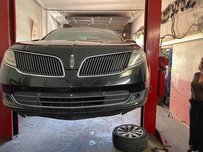 Black Lincoln MKS raised on the lift